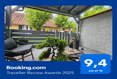 a patio with a fence and a table with a bottle of wine at Zeleni Biser -Terme Čatež in Čatež ob Savi