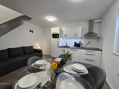 a living room with a table and chairs and a kitchen at Zeleni Biser -Terme Čatež in Čatež ob Savi