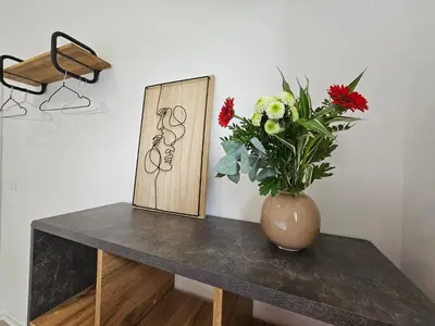 a vase of flowers on a table with a picture at Zeleni Biser -Terme Čatež in Čatež ob Savi