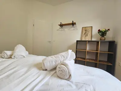 a bedroom with white towels on a white bed at Zeleni Biser -Terme Čatež in Čatež ob Savi