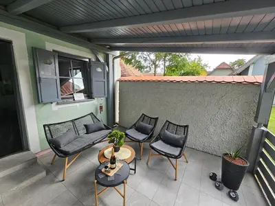 a patio with chairs and a couch and a table at Zeleni Biser -Terme Čatež in Čatež ob Savi