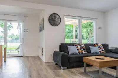a living room with a couch and a clock on the wall at Apartment Swim and Relax in Moravske Toplice