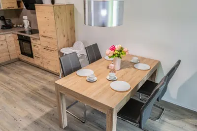 a wooden table with chairs and a vase of flowers on it at Apartment Swim and Relax in Moravske Toplice