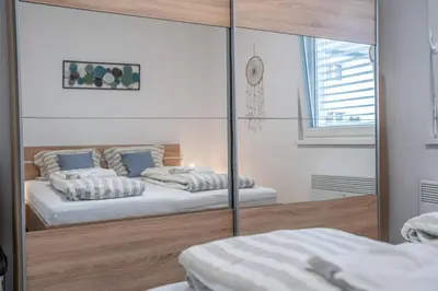 two beds in a room with a mirror at Apartment Swim and Relax in Moravske Toplice