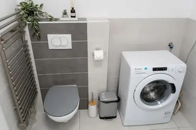 a bathroom with a washing machine and a toilet at Apartment Swim and Relax in Moravske Toplice