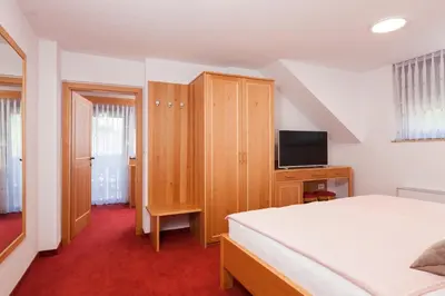 a bedroom with a bed and a cabinet and a television at Turistična kmetija Pri Marku in Žabnica