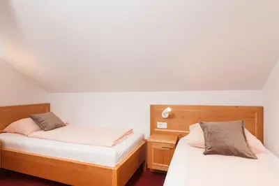 two beds in a bedroom with white walls at Turistična kmetija Pri Marku in Žabnica