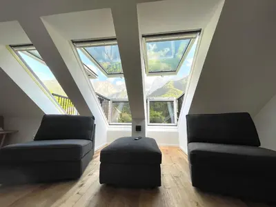a living room with two couches and three windows at Walter Apartments in Gozd Martuljek