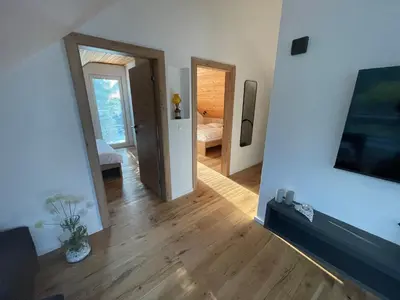 a living room with a hallway with a television and a room at Walter Apartments in Gozd Martuljek