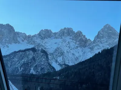 a view of a snowy mountain range from a train window at Walter Apartments in Gozd Martuljek