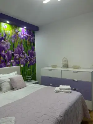 a bedroom with a bed with a flower mural on the wall at Apartment Anaa in Radovljica