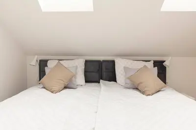 a white bed with pillows on top of it at Apartment Božica in Ljubljana