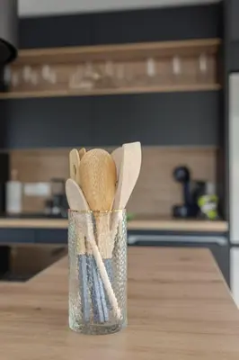 a container filled with wooden utensils sitting on a table at Apartment Božica in Ljubljana
