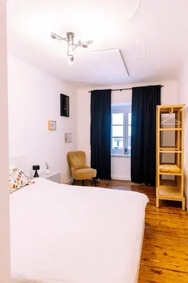 a bedroom with a white bed and blue curtains at Cozy flat in Center in Maribor