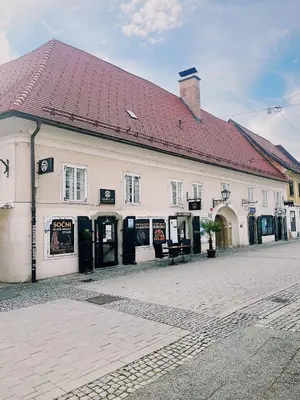 a white building with a red roof on a street at Cozy flat in Center in Maribor