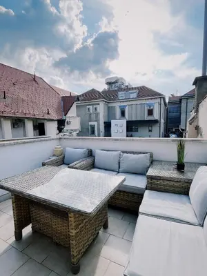 a patio with a table and chairs on a balcony at Cozy flat in Center in Maribor