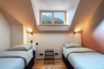 a attic room with three beds and a window at Apartment MYSA, Nordic House, Kranjska Gora - Center in Kranjska Gora