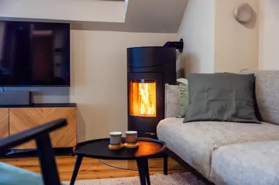a living room with a couch and a fire place at Apartment MYSA, Nordic House, Kranjska Gora - Center in Kranjska Gora