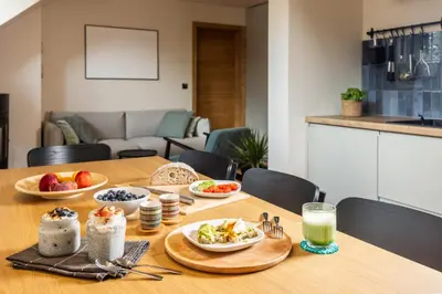 a wooden table with plates of food on it at Apartment MYSA, Nordic House, Kranjska Gora - Center in Kranjska Gora