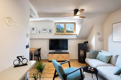 a living room with a couch and a tv at Apartment MYSA, Nordic House, Kranjska Gora - Center in Kranjska Gora