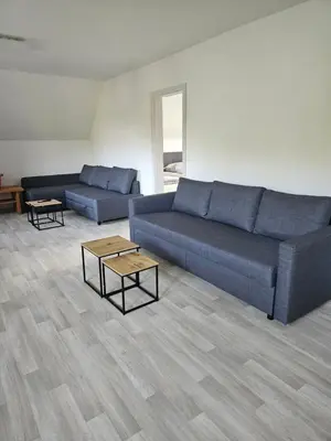 a living room with a blue couch and tables at Apartments Zalar Bled in Bled