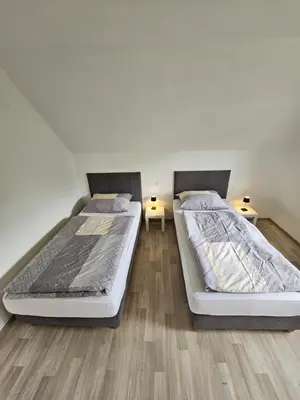two twin beds in a room with two tables at Apartments Zalar Bled in Bled