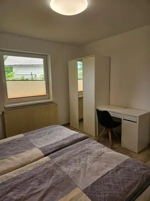 a bedroom with a bed and a desk and a window at Apartments Zalar Bled in Bled