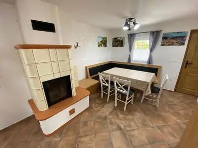 a kitchen and dining room with a table and a tv at Vineyard Cottage Joanna in Mirna Peč