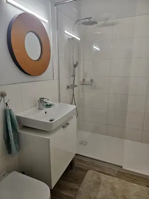 a white bathroom with a sink and a shower at Apartment Relax in Raskrižje