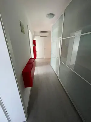 a long hallway with a red drawer in a building at Apartma S in Sežana
