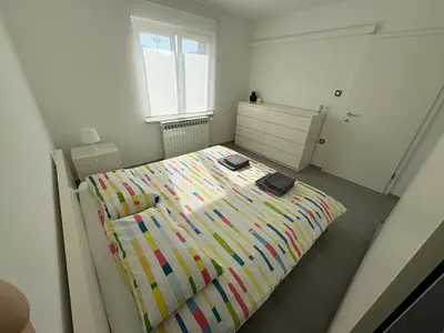 a bedroom with a large bed with a colorful blanket at Apartma S in Sežana