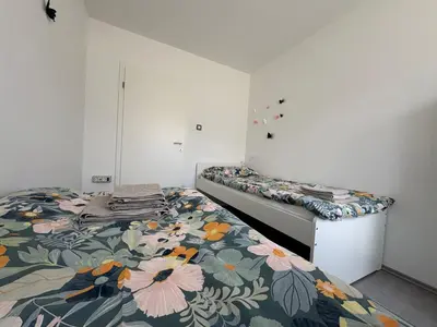 a bedroom with two beds with a floral bedspread at Apartma S in Sežana