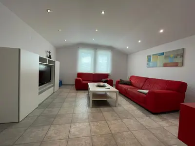 a living room with a red couch and a tv at Apartma S in Sežana