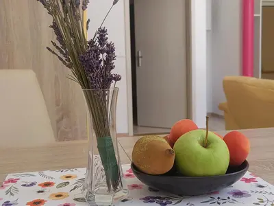 a bowl of fruit and a vase of flowers on a table at WoW sleeping in Miklavž na Dravskem Polju