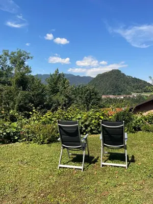 two chairs sitting on the grass in the yard at Apartma Savan in Tolmin