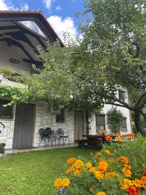 a house with a yard with flowers in front of it at Apartma Savan in Tolmin