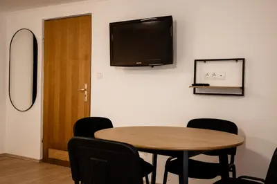 a room with a table and a television on the wall at Brodnik Apartment in Trbonje