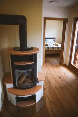 a fireplace in a room with a room with a bed at 4 Sheeps Apartments in Bovec