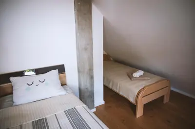 a small room with a bed with a pillow and a bench at 4 Sheeps Apartments in Bovec