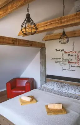 a room with a bed and a red chair at 4 Sheeps Apartments in Bovec