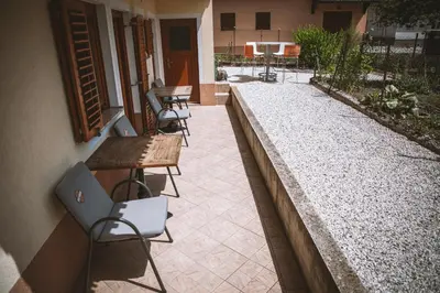 a patio with tables and chairs next to a building at 4 Sheeps Apartments in Bovec