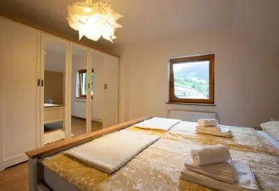 a bedroom with a large bed with towels on it at Apartment Etjan in Zgornje Gorje