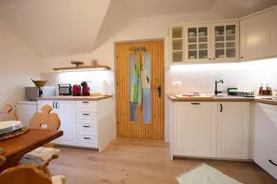 a kitchen with white cabinets and a wooden table at Apartment Etjan in Zgornje Gorje