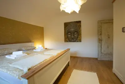 a bedroom with a bed with a head on the wall at Apartment Etjan in Zgornje Gorje