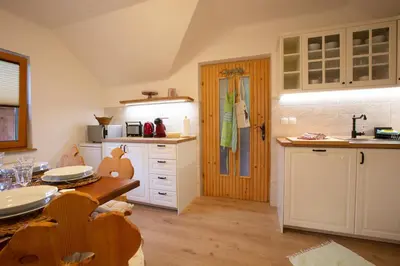 a kitchen with white cabinets and a wooden table at Apartment Etjan in Zgornje Gorje