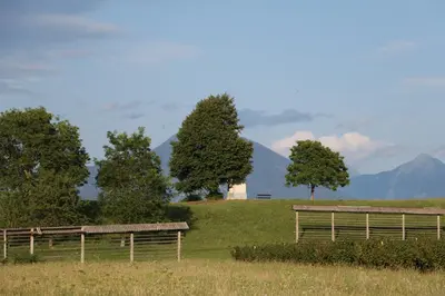 a fence in a field with mountains in the background at Studio Pr' Oreharjo in Zgornje Gorje
