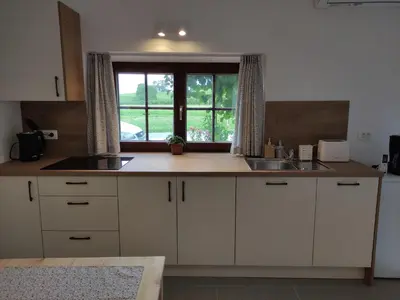a kitchen with white cabinets and a window and a sink at Studio Pr' Oreharjo in Zgornje Gorje