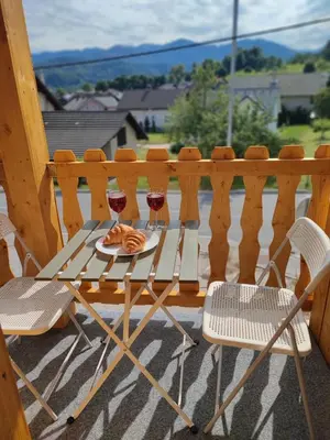 a table with two glasses of wine on a porch at Slovenian House Mira in Zgornje Gorje