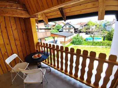 a balcony with a table and chairs and a view of a yard at Slovenian House Mira in Zgornje Gorje