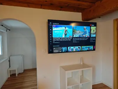 a flat screen tv hanging on a wall at Slovenian House Mira in Zgornje Gorje
